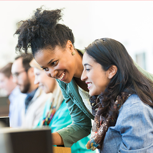 Women teaching another women something on the computer 